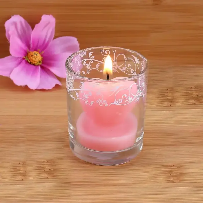 Bezaubernde Herzförmige rosa Kerze im Glas